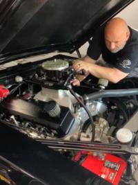 Man working under hood of car